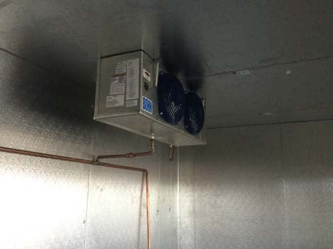 a room that has a heater and some wires on the ceiling